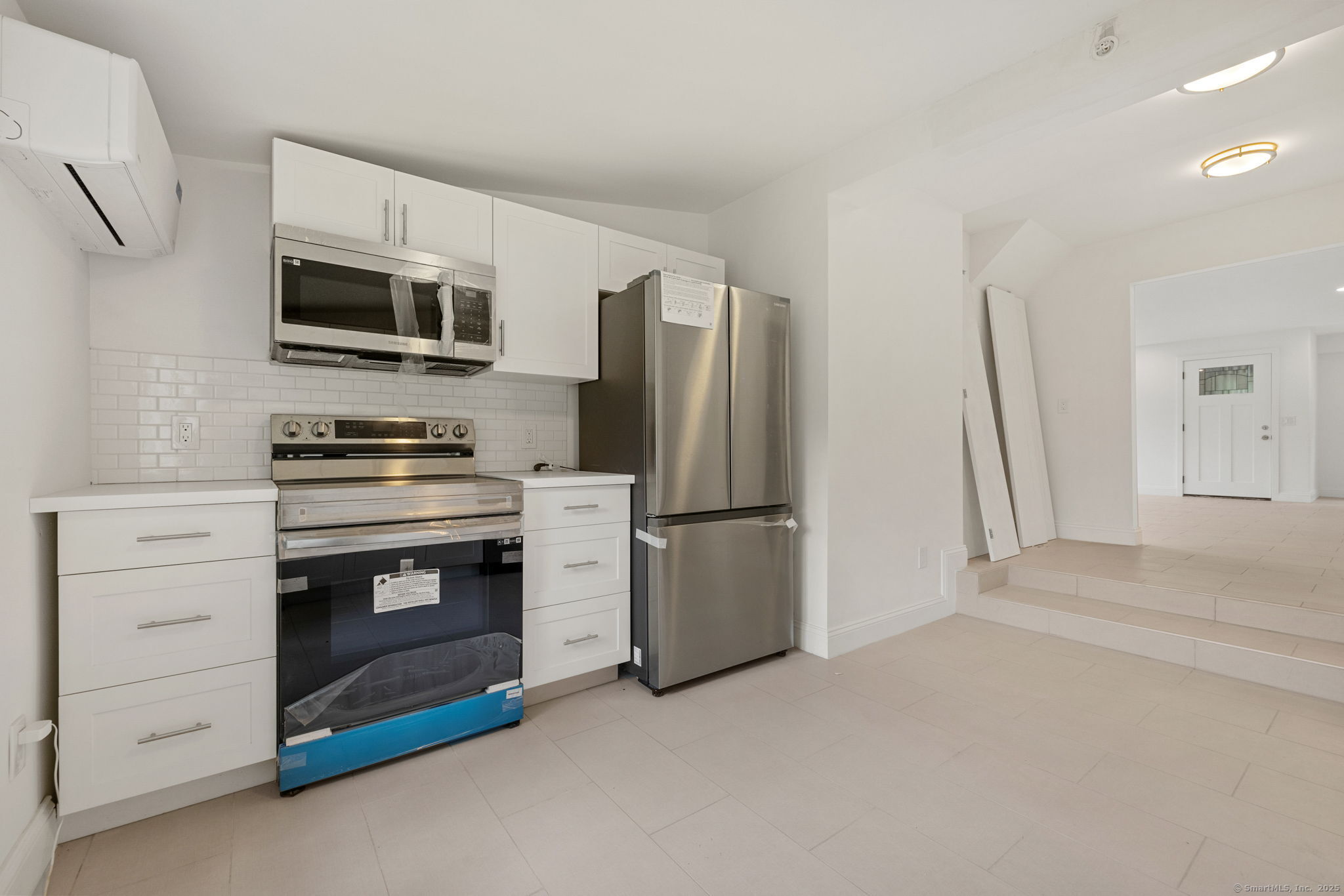 529 Danbury Road, Unit C Wilton, CT 06897 - Photo 5 of 21 a kitchen with stainless steel appliances a refrigerator stove and microwave
