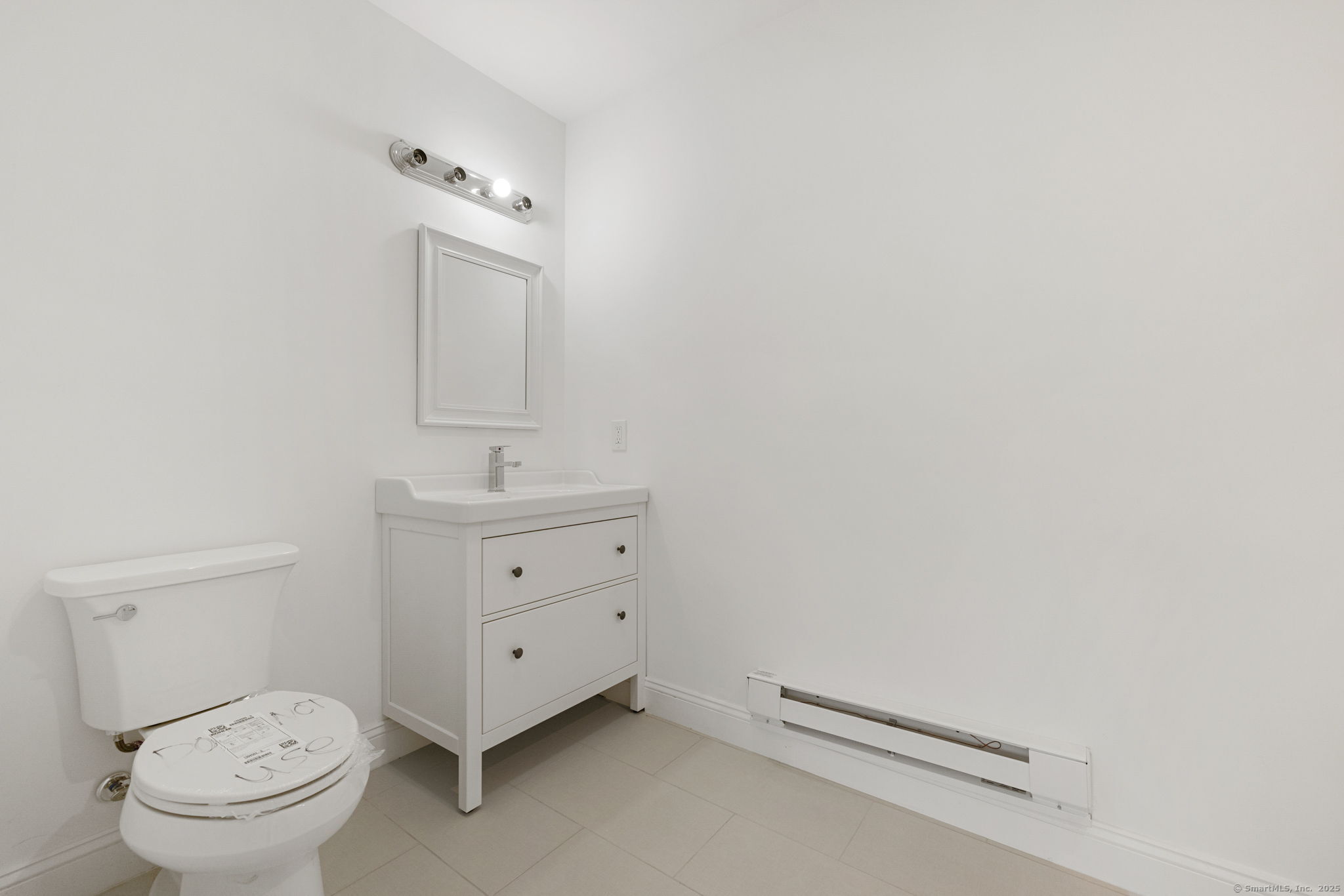 529 Danbury Road, Unit C Wilton, CT 06897 - Photo 6 of 21 a bathroom with a toilet sink and mirror