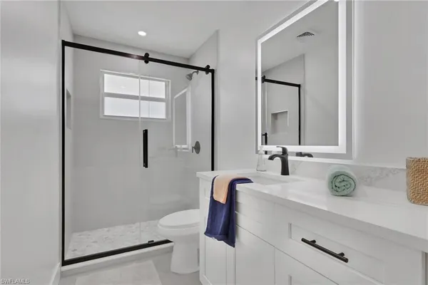 a bathroom with a sink a toilet and shower