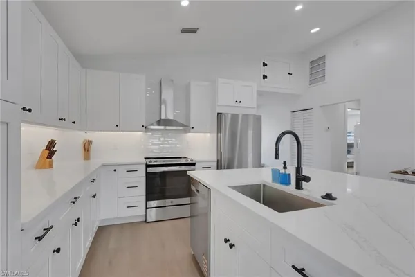 a kitchen with granite countertop a white stove and white cabinets