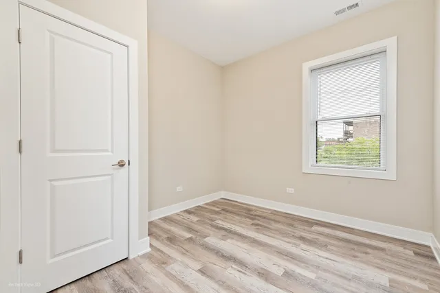 an empty room with windows and closet