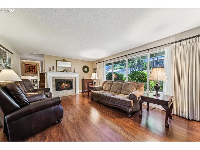 a living room with furniture a fireplace and a floor to ceiling window