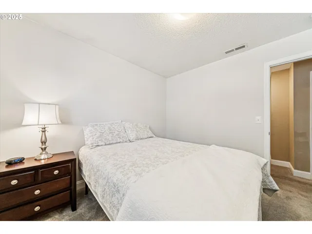 a bedroom with a bed and a night stand