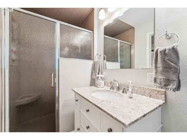 a bathroom with a sink vanity granite and a mirror