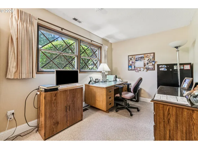 a view of a workspace with furniture and a window