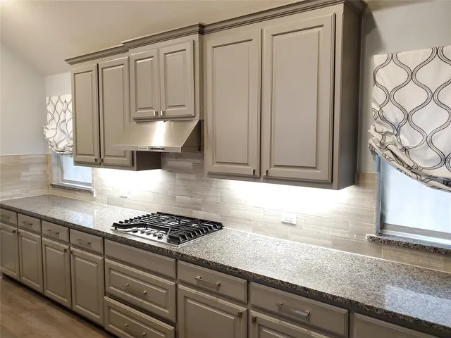 a kitchen with granite countertop cabinets and stove