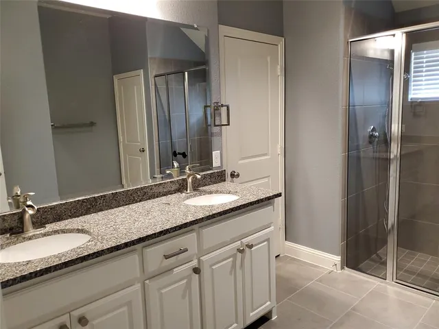a bathroom with a granite countertop sink double and mirror