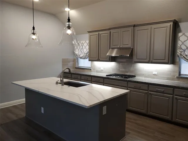 a kitchen with a sink dishwasher a stove and a refrigerator with wooden floor