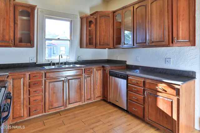 a view of a kitchen with refrigerator and wooden floor