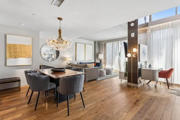 a view of a a dining room with furniture window and wooden floor