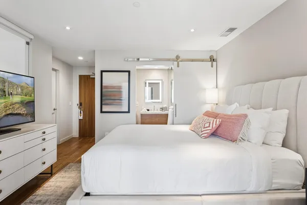 a bedroom with a large bed and a flat screen tv