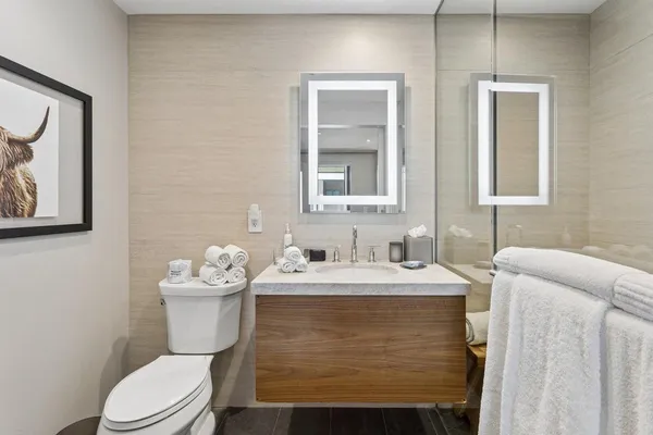 a bathroom with a toilet sink and mirror