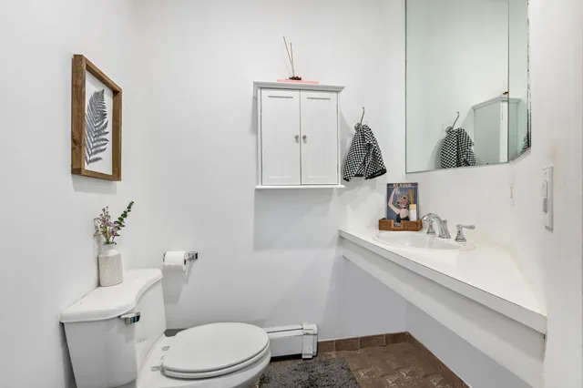 a bathroom with a toilet sink and mirror