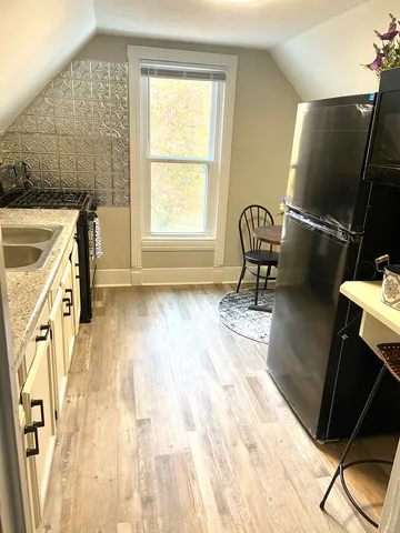 a view of a kitchen with a sink wooden floor and furniture