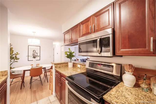 a kitchen with a stove a microwave and living room