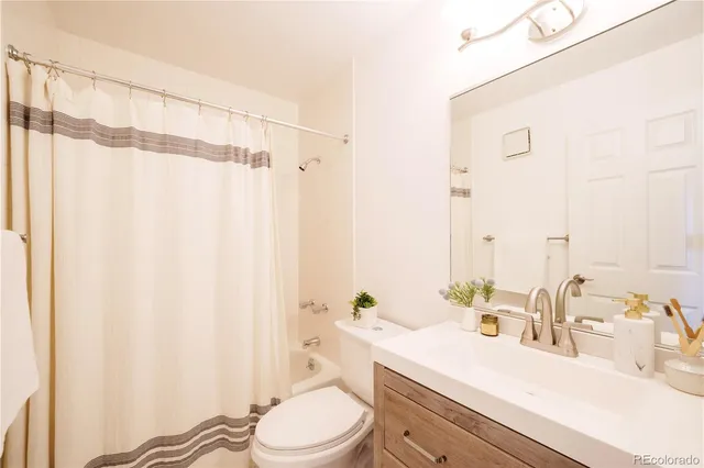 a bathroom with a sink a toilet and shower curtain