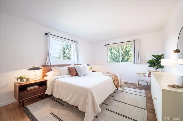 a bedroom with a bed wooden floor and window