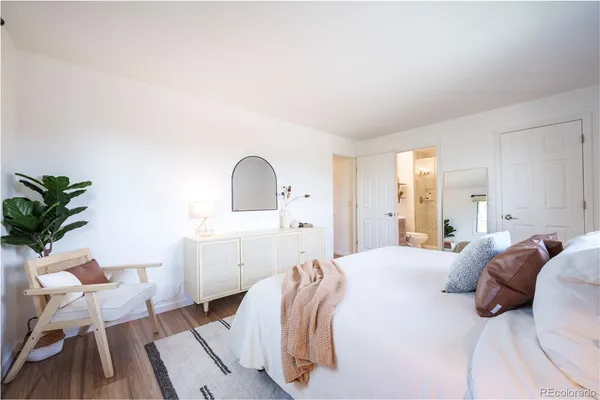 a bedroom with a bed and a potted plant