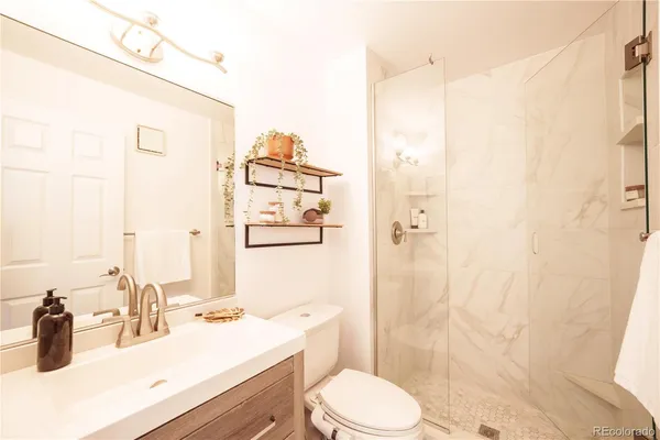 a bathroom with a sink a toilet and shower