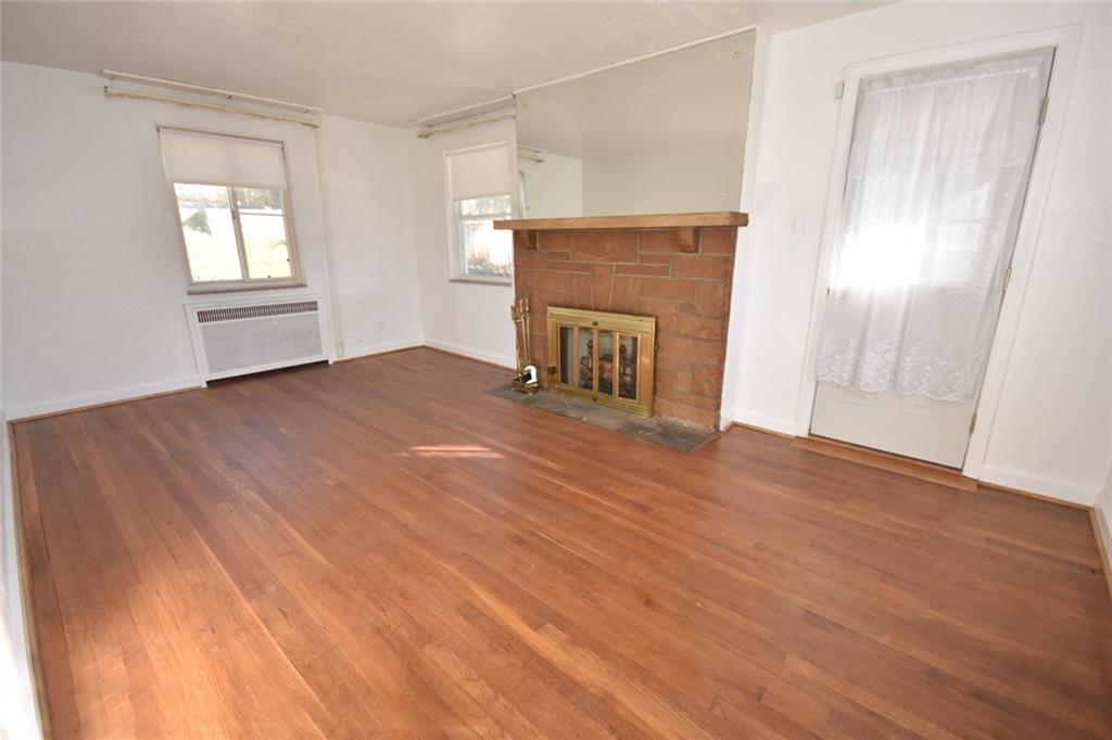575 Kelso Road Pittsburgh, PA 15243 - Photo 3 of 24 A spacious living room with access to the side patio, a wood burning fireplace and plenty of natural lighting as well as hard wood floors showcase this area.