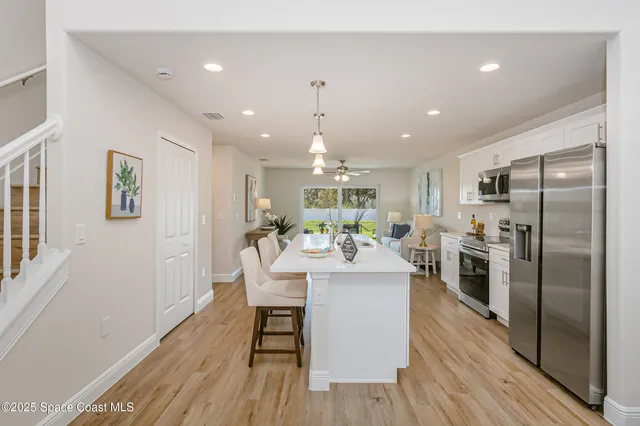 a view of a kitchen with dining table and stainless steel appliances