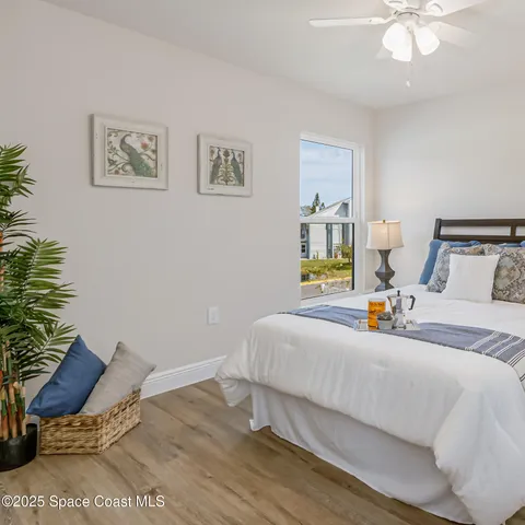 a bedroom with a bed and wooden floor