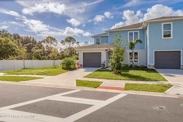 a view of a house with a backyard and a garage