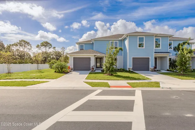 a view of a white house with a swimming pool and a yard