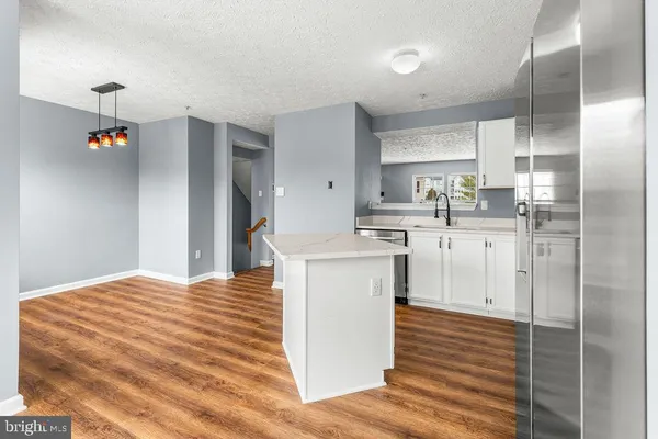 a kitchen with stainless steel appliances granite countertop a sink cabinets and wooden floor