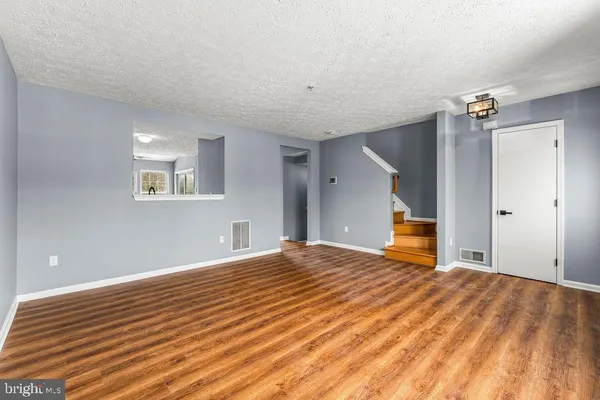 a view of a room with wooden floor and a ceiling fan
