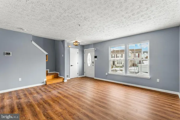 a view of a livingroom with a window and wooden floor