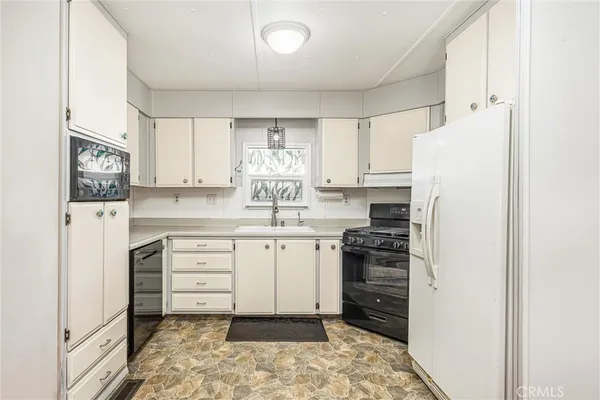 a kitchen with white cabinets and white appliances