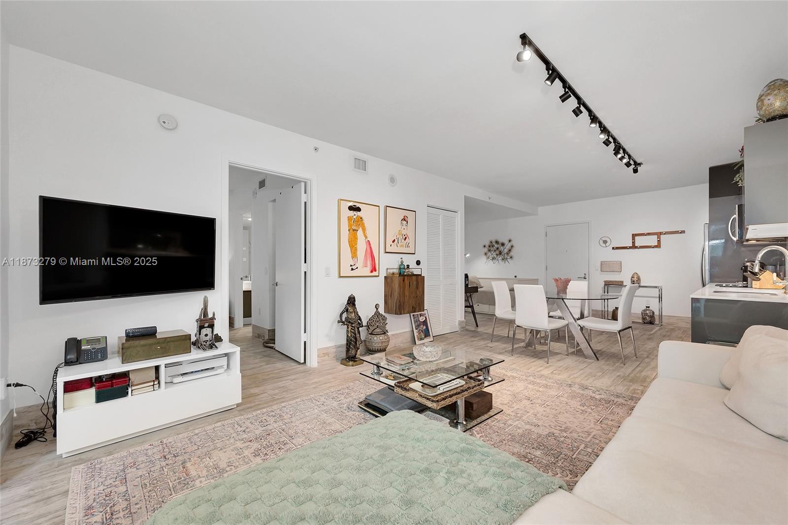 31 Southeast 6th Street, Unit 304 Miami, FL 33131 - Photo 15 of 23 a living room with furniture and a flat screen tv