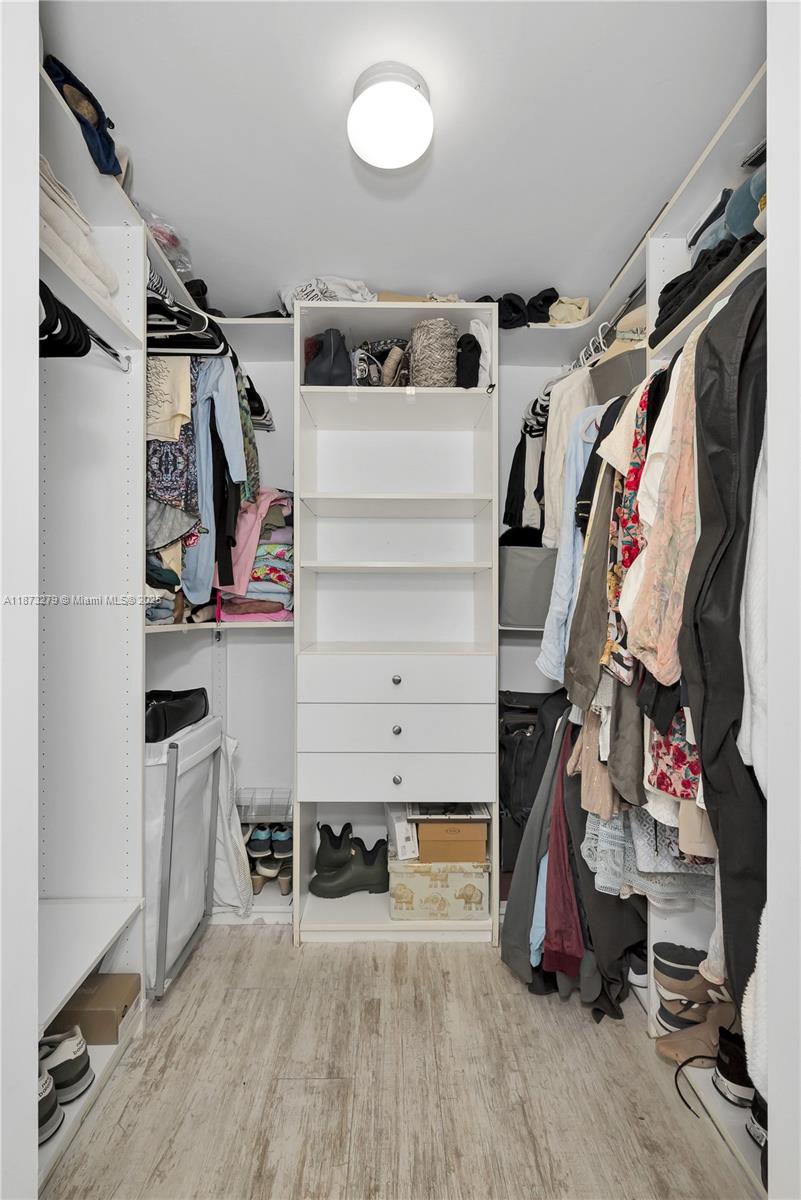 31 Southeast 6th Street, Unit 304 Miami, FL 33131 - Photo 16 of 23 a view of walk in closet with clothes and shoes