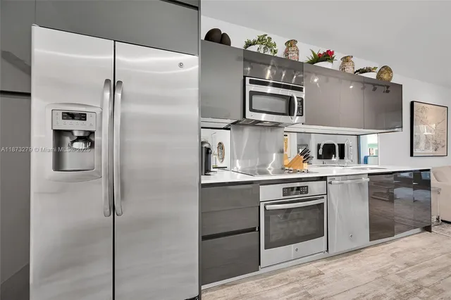 a kitchen with stainless steel appliances granite countertop a refrigerator and a sink