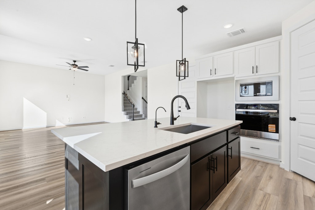 4737 Pleasant Place Round Rock, TX 78665 - Photo 29 of 30 a kitchen that has a sink a stove and a wooden floor