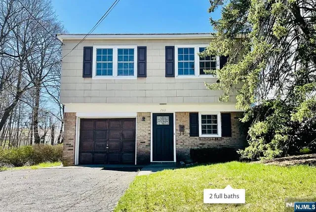 a front view of a house with yard and green space
