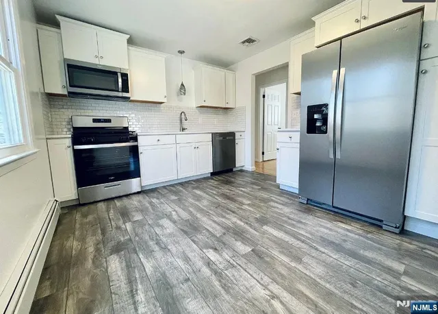 a kitchen with granite countertop a refrigerator stove and microwave