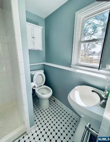 a bathroom with a toilet a sink and a window