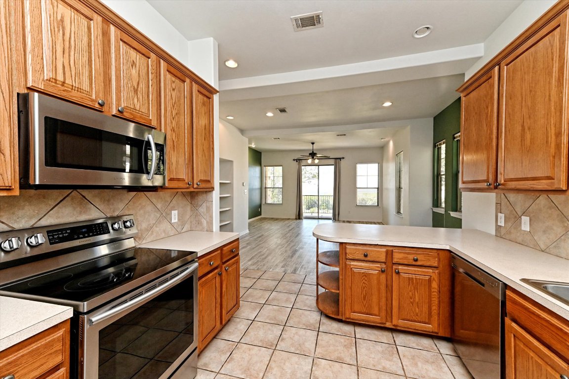 4307 Eck Lane, Unit 107 Austin, TX 78734 - Photo 11 of 28 a kitchen with stainless steel appliances granite countertop a stove a sink and a microwave