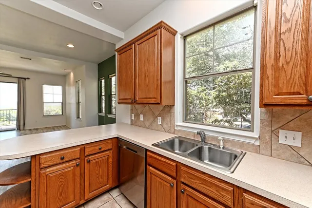 a kitchen with granite countertop a sink and wooden cabinets
