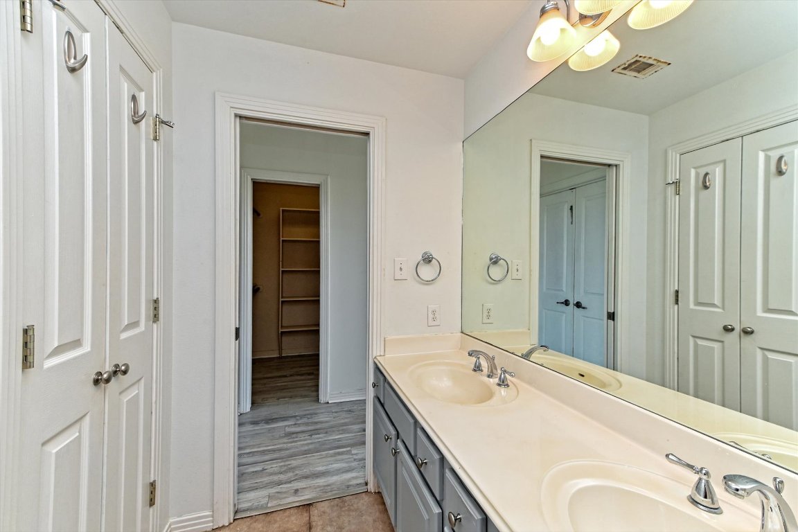 4307 Eck Lane, Unit 107 Austin, TX 78734 - Photo 20 of 28 a spacious bathroom with a double vanity sink mirror and hallway