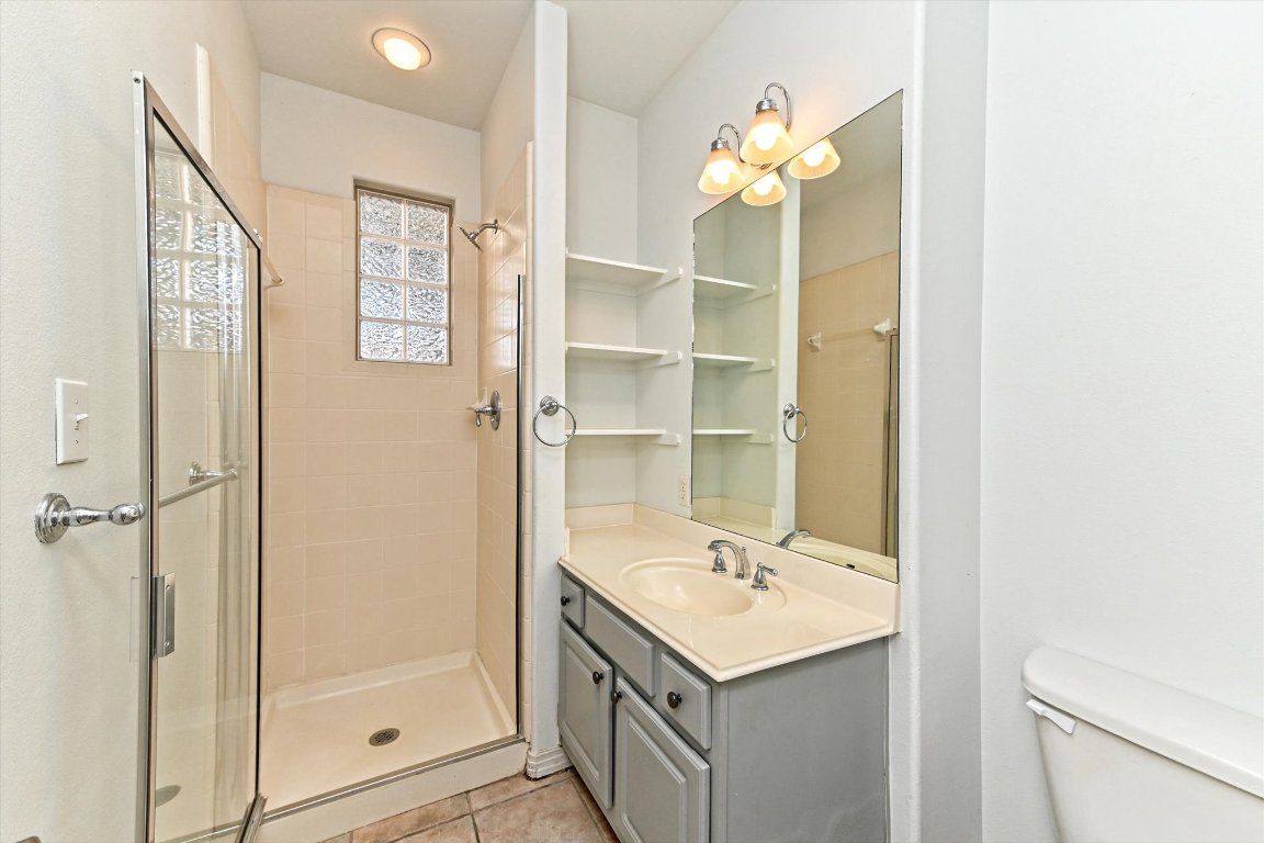 4307 Eck Lane, Unit 107 Austin, TX 78734 - Photo 23 of 28 a bathroom with a sink a mirror and a shower