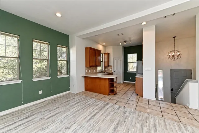 a view of a kitchen with kitchen island a sink wooden floor and a window
