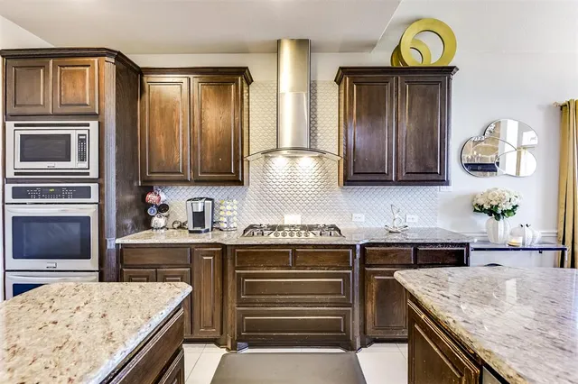 a kitchen with stainless steel appliances granite countertop a sink and a stove