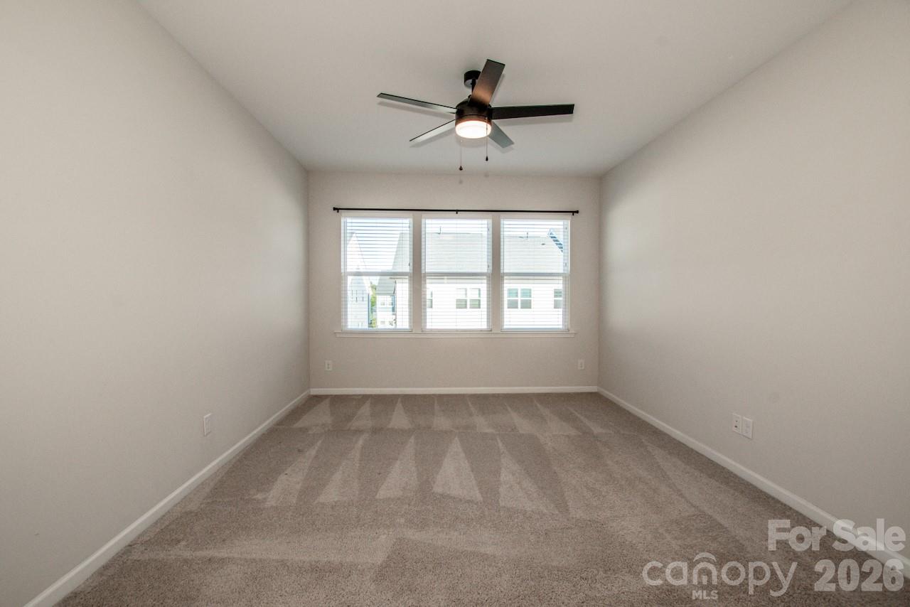 1270 Brawley School Road, Unit F Mooresville, NC 28117 - Photo 22 of 37 an empty room with ceiling fan and windows