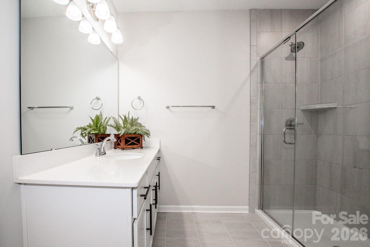 1270 Brawley School Road, Unit F Mooresville, NC 28117 - Photo 27 of 37 a bathroom with a sink a mirror and a shower