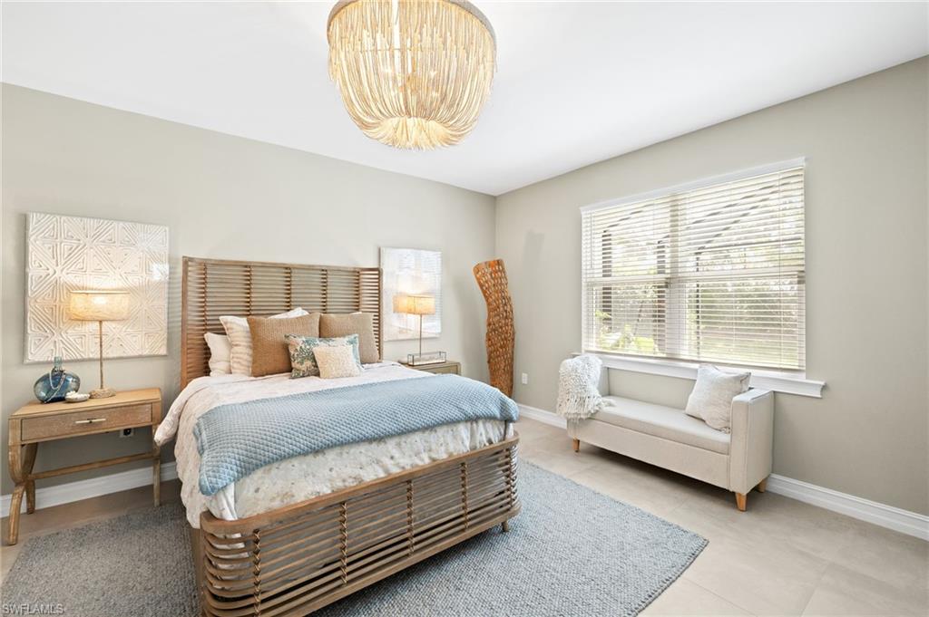 14546 Tropical Drive Naples, FL 34114 - Photo 13 of 38 a bedroom with a bed and a chandelier
