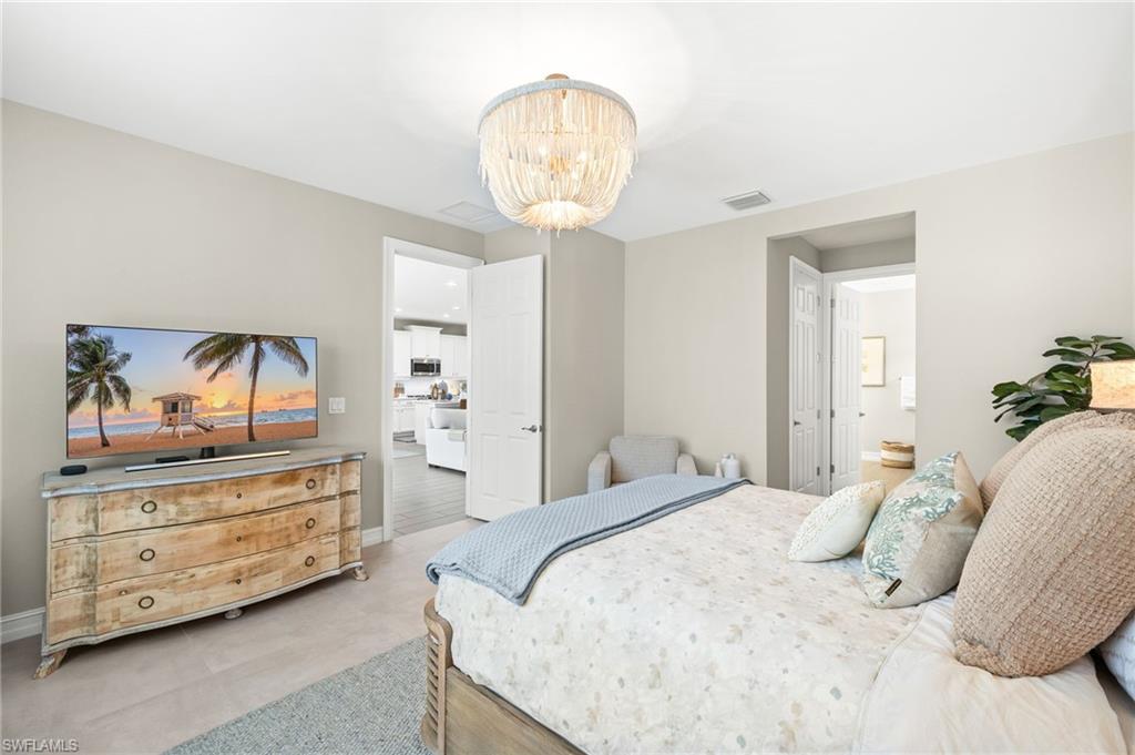 14546 Tropical Drive Naples, FL 34114 - Photo 14 of 38 a bedroom with a bed and a chandelier