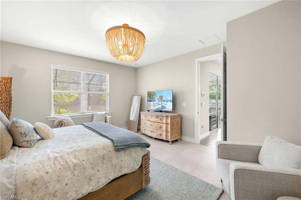 14546 Tropical Drive Naples, FL 34114 - Photo 15 of 38 a bedroom with a bed and a chandelier